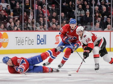 Montreal Canadiens centre Lars Eller, left, falls as he and teammate Jacob De La Rose, centre, fight for the puck against Ottawa Senators left wing Mike Hoffman, right, during the second period.
