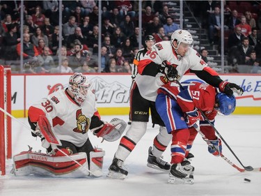 Ottawa Senators defenseman Patrick Wiercioch, centre, pushes Montreal Canadiens center David Desharnais, right, as they fight for the puck in front of Ottawa Senators goalie Andrew Hammond, left, during the second period.