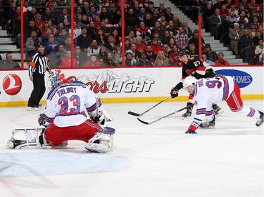 Curtis Lazar #27 of the Ottawa Senators shoots the puck past Cam Talbot #33 of the New York Rangers as Keith Yandle #93 of the New York Rangers looks on in the first period.