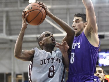 Ottawa Gee Gees' Johnny Berhanemeskel (8) drives to the basket as Bishop's Gaiters' Kyle Desmarais (8) defends during first half CIS Final Eight basketball action in Toronto on Thursday, March 12, 2015.