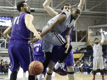 Ottawa Gee Gees' Johnny Berhanemeskel loses control of the ball as Bishop's Gaiters' Majid Naji and Mike Andrews defend aduring first half CIS Final Eight basketball action in Toronto on Thursday, March 12, 2015.