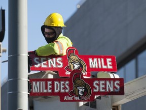 OTTAWA, ONT., JAN 24, 2013 -- City of Ottawa employee Mark Bradley installs "Sens Mile" signs, in English and French, on a streetlight pole at Laurier St. and Elgin St. (DAVID LAFERRIERE/Ottawa Citizen). For CITY story. Assignment #111818