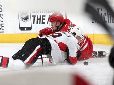 Andrej Nestrasil #15 of the Carolina Hurricanes gets tangled up on the ice with Milan Michalek #9 of the Ottawa Senators.