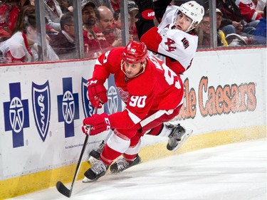 Stephen Weiss #90 of the Detroit Red Wings battles along the boards with Jean-Gabriel Pageau #44 of the Ottawa Senators.