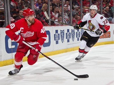 DETROIT, MI - MARCH 31:  Henrik Zetterberg #40 of the Detroit Red Wings controls the puck in the corner as Erik Condra #22 of the Ottawa Senators gives chase during a NHL game on March 31, 2015 at Joe Louis Arena in Detroit, Michigan.