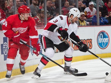 Gustav Nyquist #14 of the Detroit Red Wings battles for the puck with Marc Methot #3 of the Ottawa Senators.
