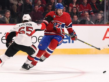 Brandon Prust #8 of the Montreal Canadiens tries to keep the puck from Erik Karlsson #65 of the Ottawa Senators.