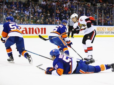 Erik Karlsson #65 of the Ottawa Senators shoots against Johnny Boychuk #55 of the New York Islanders.