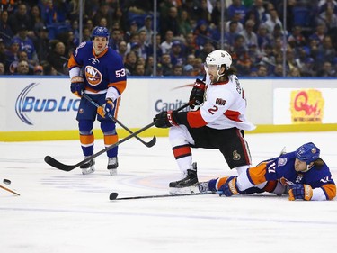 UNIONDALE, NY - MARCH 13:  Jared Cowen #2 of the Ottawa Senators shoots against Matt Martin #17 of the New York Islanders during their game at the Nassau Veterans Memorial Coliseum on March 13, 2015 in Uniondale, New York.