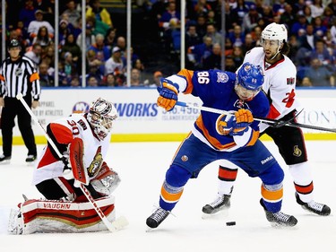 Andrew Hammond #30 of the Ottawa Senators defends the net as Nikolay Kulemin #86 of the New York Islanders attempts to control the puck.