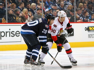 Lee Stempniak #20 of the Winnipeg Jets and Alex Chiasson #90 of the Ottawa Senators get set for a first period face-off.