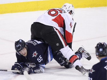 Mark Scheifele #55 of the Winnipeg Jets gets tangled up with Patrick Wiercioch #46 of the Ottawa Senators in first-period action.
