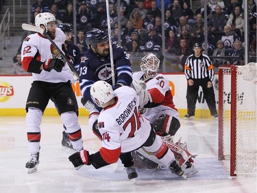 Dustin Byfuglien #33 of the Winnipeg Jets takes down Mark Borowiecki #74 of the Ottawa Senators in second-period action.