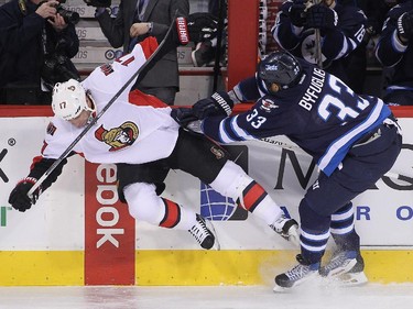 Dustin Byfuglien #33 of the Winnipeg Jets takes down David Legwand #17 of the Ottawa Senators in first-period action.