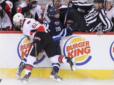 Eric Gryba #62 of the Ottawa Senators and Lee Stempniak #20 of the Winnipeg Jets collide against the boards in first-period action.