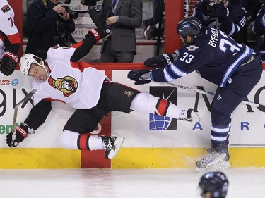 Dustin Byfuglien #33 of the Winnipeg Jets takes down David Legwand #17 of the Ottawa Senators in first-period action.