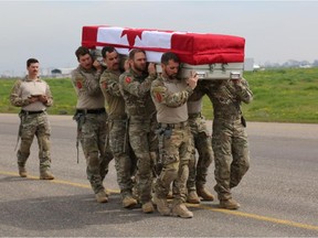 Pallbearers from the Canadian Special Operations Regiment (CSOR) carry the casket of their fallen comrade, Sergeant Andrew Joseph Doiron, during the ramp ceremony at the Erbil International Airport, Iraq, on March 8, 2015.