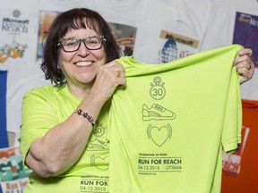 Paula Agulnik, executive director of Run for Reach,  holds up a promotional athletic shirt in her office on March 25, 2015. Each year, she says, Reach assists 'hundreds of people with all types of disabilities.'