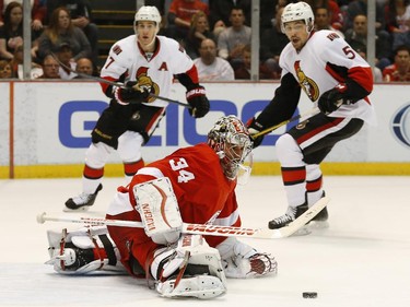 Detroit Red Wings goalie Petr Mrazek (34) stops an Ottawa Senators shot as Kyle Turris (7) and Cody Ceci (5) look on in the first period.