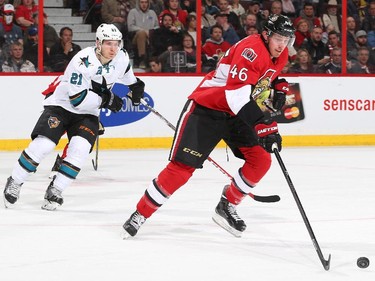 Patrick Wiercioch #46 of the Ottawa Senators turns up ice with the puck against Ben Smith #21 of the San Jose Sharks.