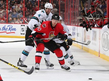 Brenden Dillon #4 of the San Jose Sharks battles for position against Alex Chiasson #90 of the Ottawa Senators.