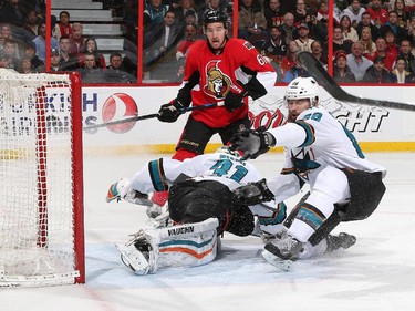 Antti Niemi #31 and Brent Burns #88 of the San Jose Sharks defend their net against Mark Stone #61 of the Ottawa Senators.