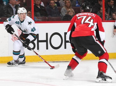 Tomas Hertl #48 of the San Jose Sharks looks to set up a pass against Mark Borowiecki #74 of the Ottawa Senators.