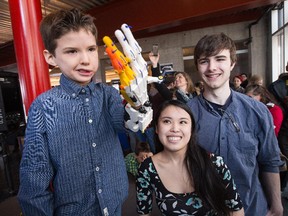 Sebastian Chavarria, 6, shows off the prototype of the winning design for a new prosthetic hand. The team of Shannon Lee and Robert Rayson (pictured here) were chosen from 4 different design teams put together by the University of Ottawa engineering department and competed for a prize of $1000. The challenge was to use 3D printers as an innovative approach to prosthetic production.