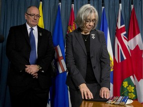 Sheila Fynes touches the beret of her son as she and her husband Shaun Fynes attend a news conference about the Final Report of the Fynes Public Inquiry during a news conference, Tuesday, March 10, 2015 in Ottawa. A report into how the military handled the 2008 suicide of an Afghan veteran says the family of Cpl. Stuart Langridge was disrespected, ignored and given potentially misleading information.But the Military Police Complaints Commission says it wasn't done out of bias or a lack of independence on the part of military police. THE CANADIAN PRESS/Adrian Wyld


// na031115-langridge