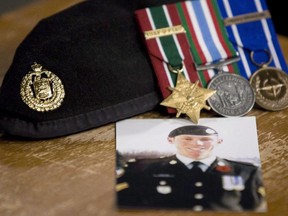 A photo of Cpl. Stuart Langridge is seen along with his beret and medals on a table during a news conference on Parliament Hill in Ottawa on October 28, 2010.