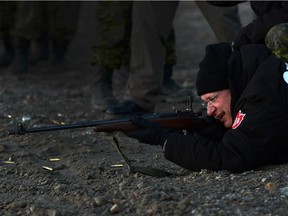 Prime Minister Stephen Harper shoots a .303 Lee Enfield rifle while taking part in demonstration from Canadian Rangers near the Artic community of Gjoa Haven, Nunavut on Aug. 20, 2013.