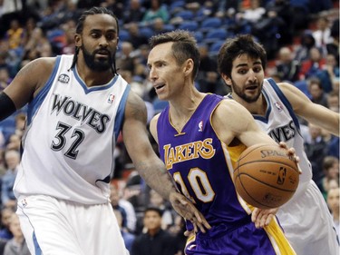 Los Angeles Lakers' Steve Nash, center, drives as Minnesota Timberwolves' Ronny Turiaf, left, of France, and Ricky Rubio, of Spain, defend during the second half of an NBA basketball game, Tuesday, Feb. 4, 2014, in Minneapolis. The Timberwolves won 109-99. Nash had been sidelined since Nov. 10 because of nerve problems in his back.
