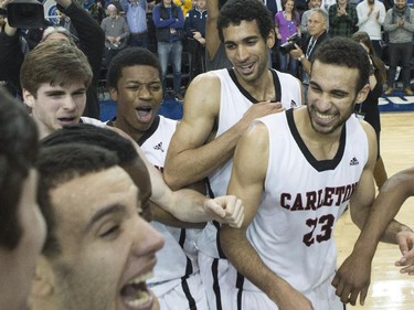 Carleton Ravens' Thomas Scrubb (centre right) and his brother Philip Scrubb (right) celebrate with teammates after defeating the Ottawa Gee-Gees to win the CIS basketball final in Toronto on Sunday, March 15, 2015.