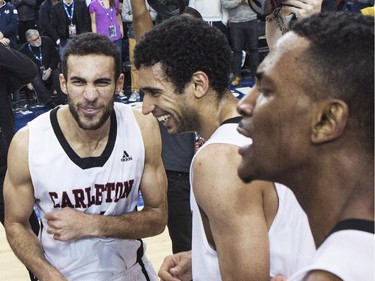 Carleton Ravens Philip Scrubb (left) and his brother Thomas Scrubb (centre) celebrate with teammates after defeating the Ottawa Gee-Gees to win the CIS basketball final in Toronto on Sunday March 15 , 2015.