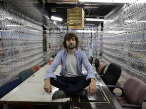 TerraCycle founder Tom Szaky sits on a table made from old doors in his New Jersey office where dividing walls are made of used pop bottles.