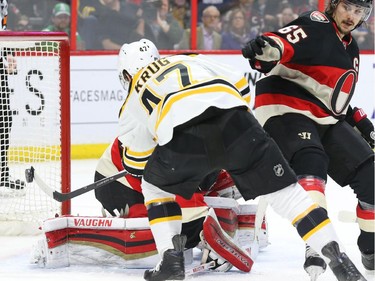 Trey Krug of the Boston Bruins scores on Andrew Hammond of the Ottawa Senators during second period NHL action.