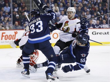 Ottawa Senators' Mark Borowiecki (74) clears Winnipeg Jets' Dustin Byfuglien (33) and Mark Scheifele (55) from in front of Sens goaltender Andrew Hammond's (30) net during second period NHL action.