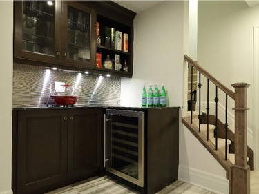 Downstairs, the finished basement includes a small wet bar by the stairs.