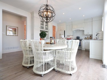 The creamy white kitchen shares the back of the house with a breakfast area and comfy family room.