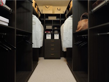 The master walk-in closet, on the other hand, features rich, dark cabinetry and plenty of storage space.