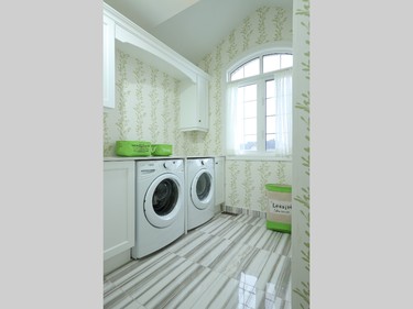 The lime green and white laundry room has a premium second-floor location, featuring angled ceiling lines and a large curved palladian window looking over the street.