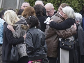 Grieving family and friends embrace after the funeral Thursday for Connor Stevenson at Rothwell United Church in Beacon Hill.