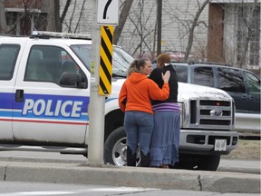 A woman is comforted after  a pedestrian was struck by a vehicle on Bank St. near South Keys in Ottawa, Wednesday, April 22, 2015. Traffic in the area was snarled during the afternoon rush hour.