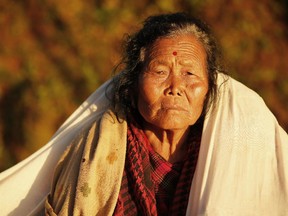 An elderly villager sits in the evening sun with a blanket in the destroyed village of Paslang near the epicenter of Saturday's massive earthquake in the Gorkha District of Nepal, Tuesday, April 28, 2015.  Military operations continue Tuesday to reach the isolated areas following the powerful earthquake that has devastated the nation and killed at least 4,400 people, according to district official Surya Mohan Adhikari.