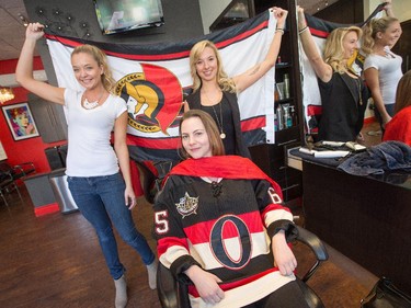 Hairstylists Stephanie O'Halloran (L), and Sophie Gordon (R) from Hair Dynamics on Elgin St along with customer Ashley Morrison (C) show off their Sens pride while at work Wednesday as hockey fans head to the Sensmile on Elgin Street to watch the Ottawa Senators take on the Montreal Canadiens on television in game 1 of the playoffs.