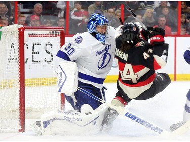 Ben Bishop of the Tampa Bay Lightning and Jean-Gabriel Pageau of the Ottawa Senators collide during first period NHL action.