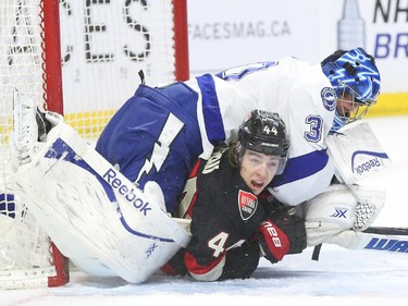 Ben Bishop of the Tampa Bay Lightning hits Jean-Gabriel Pageau of the Ottawa Senators during first period NHL action.