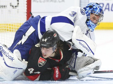Ben Bishop of the Tampa Bay Lightning hits Jean-Gabriel Pageau of the Ottawa Senators during first period NHL action.