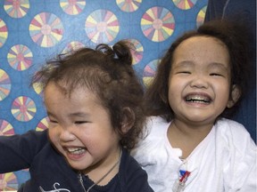 Binh (right) and Phuoc Wagner pose for a photo in Toronto, Monday, April 20, 2015. Binh, a three-year-old girl from Kingston, Ont., has received a liver transplant two months after her twin sister Phuoc underwent the same surgery to combat a potentially fatal genetic disorder.