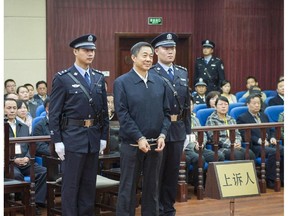 In this photo released by China's Xinhua News Agency, ousted Chinese politician Bo Xilai, centre, stands as the Shandong Provincial Higher People's Court announces the decision of the second trial of Bo, in Jinan, China's Shandong Province.